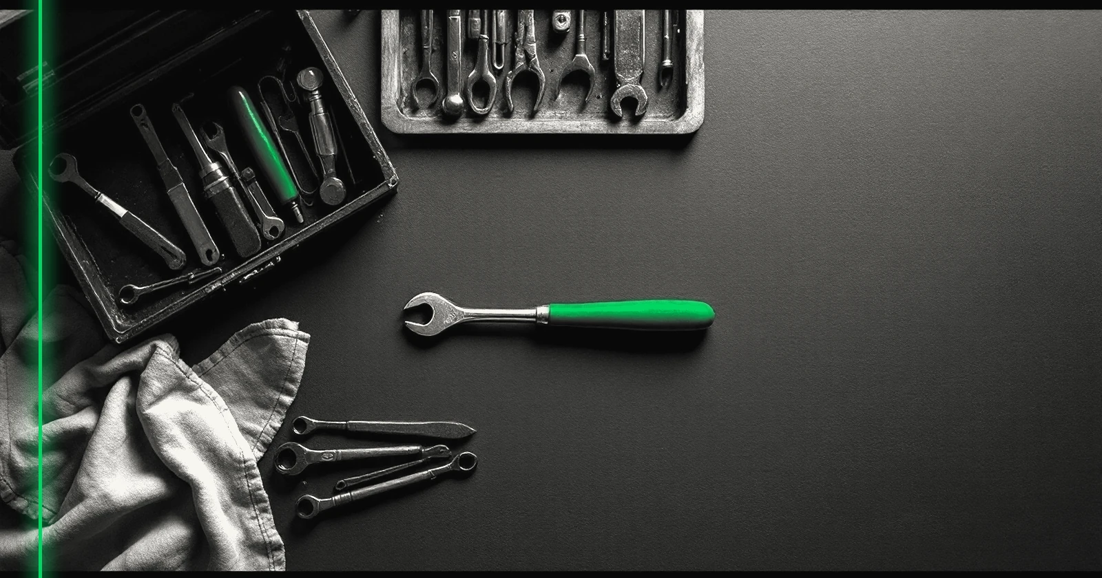 Un établi avec une caisse à outils ouverte, un seul outil sorti et posé en premier sur un tissu.